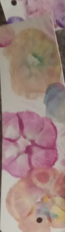 Watercolour pressed pansies in pink, peach and violet on a paper bookmark